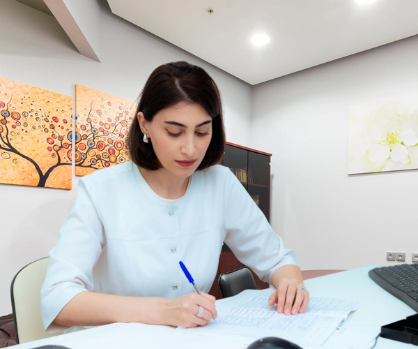 Врач пишет за рабочим столом